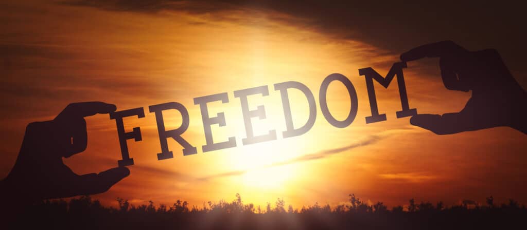 Freedom - human hands holding black silhouette word